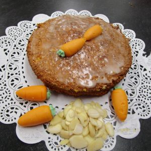 Aargauer Rüeblitorte (Argovian Carrot Cake) with main ingredients on a doilie