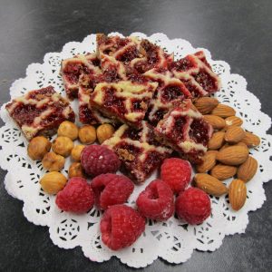 Homemade Linzer Carées (Linzer squares) with main ingredients on a doilie